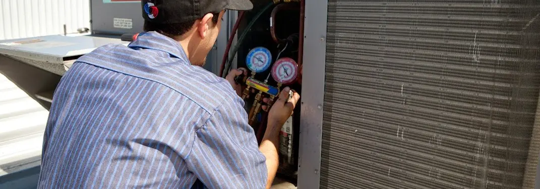 HVAC technician servicing a condenser unit in Mocksville